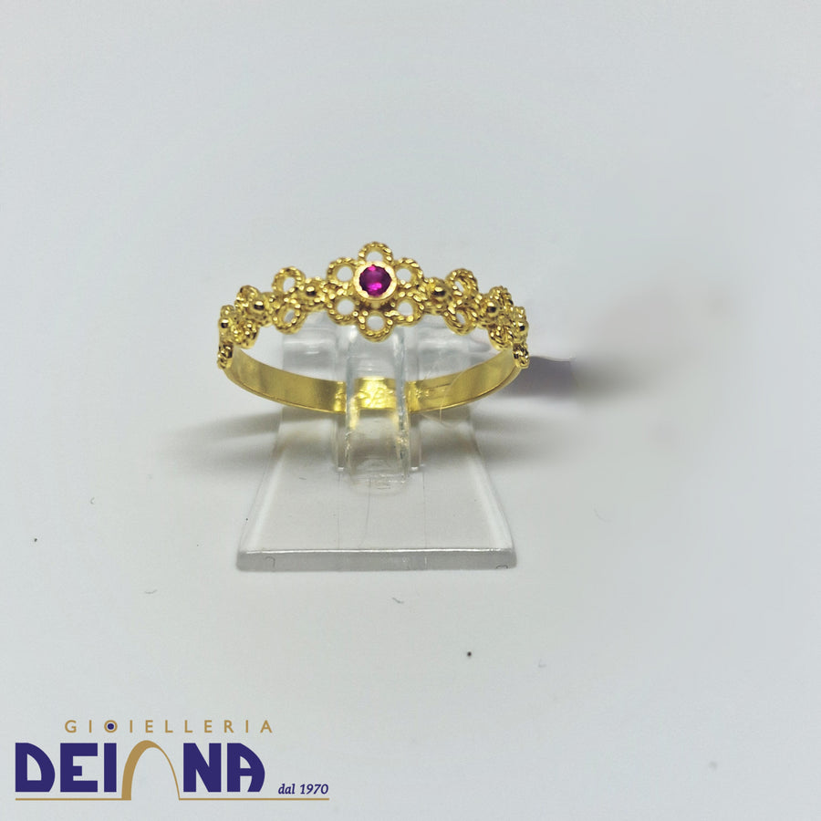 Anello stile fede sarda con granato centrale in oro giallo.