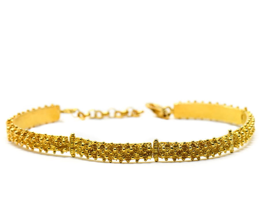 Bracciale semi rigido a nido d'ape impernato in argento dorat